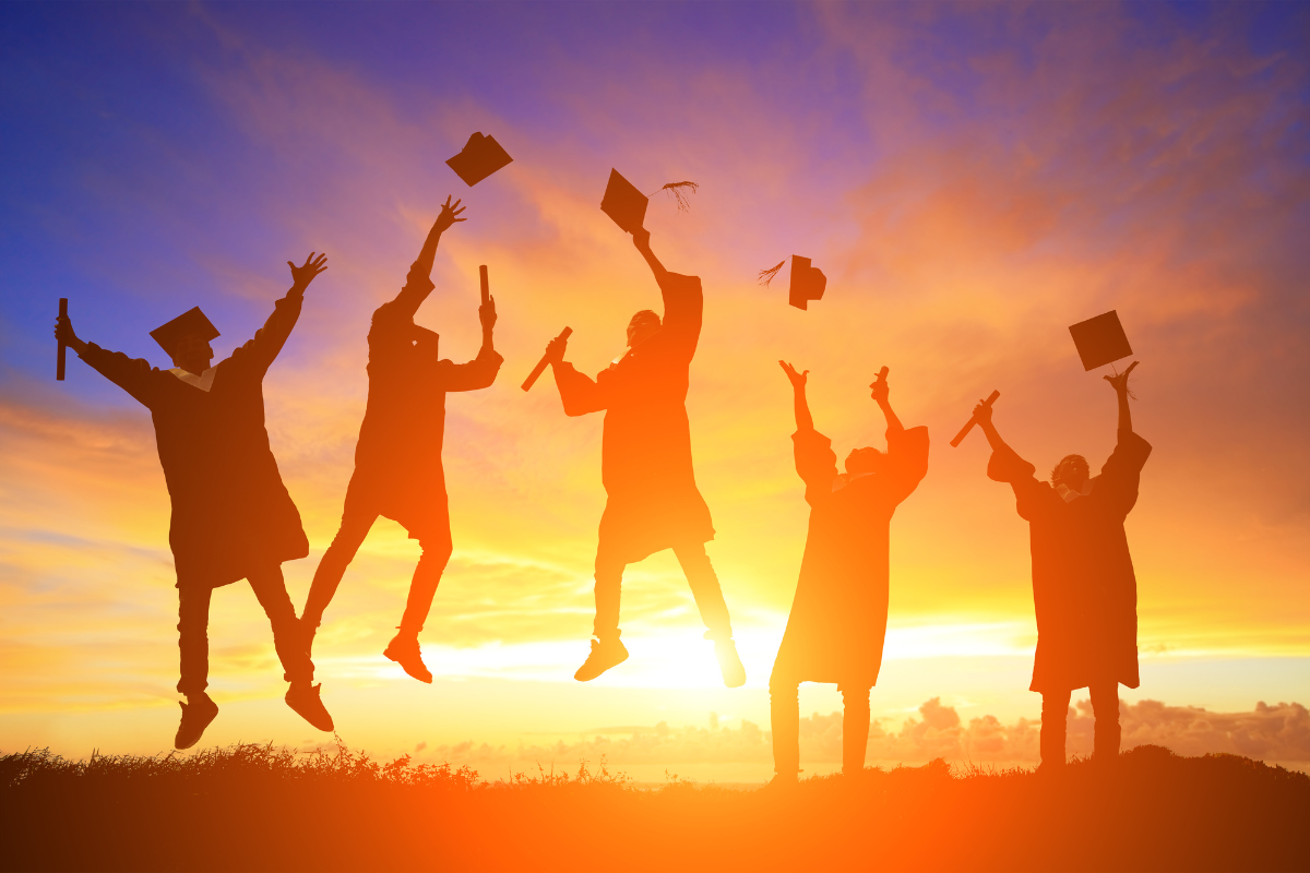post secondary education Graduates jumping in a golden sunset with their hats in the air